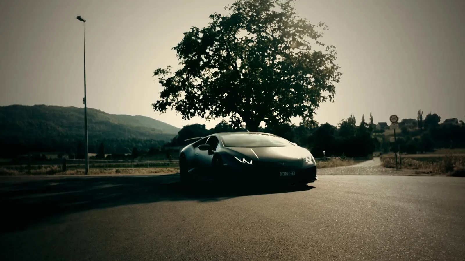 A supercar on an open road at golden hour